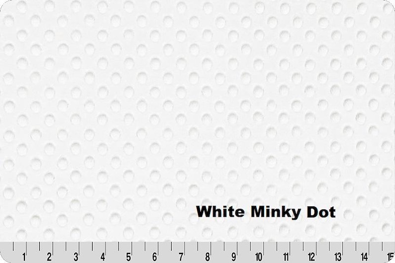 May include: White minky dot fabric with a textured surface. The fabric has a pattern of evenly spaced, small, raised dots. The text "White Minky Dot" is displayed on the fabric. A ruler is at the bottom of the image, with measurements in inches.