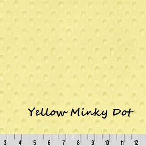 May include: A light yellow fabric with a textured dot pattern. The words "Yellow Minky Dot" are printed in black. A ruler is at the bottom of the image, with measurements in inches.