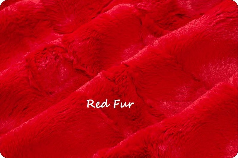 May include: Close-up of vibrant red fur fabric. The plush material has a soft, textured appearance with visible fibers. The words "Red Fur" are written in white script across the image.