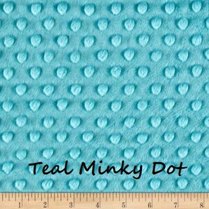Pu&ograve; includere: Tessuto Teal Minky Dot con superficie strutturata. Il tessuto presenta un motivo di punti a forma di cuore in rilievo. Il testo "Teal Minky Dot" &egrave; scritto in corsivo nero nella parte inferiore del tessuto. Un righello di legno &egrave; in basso.