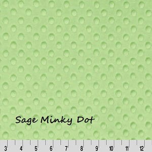 May include: Sage green Minky Dot fabric with a textured, dotted pattern. The fabric has a ruler along the bottom edge, with the text "Sage Minky Dot" in a handwritten font.