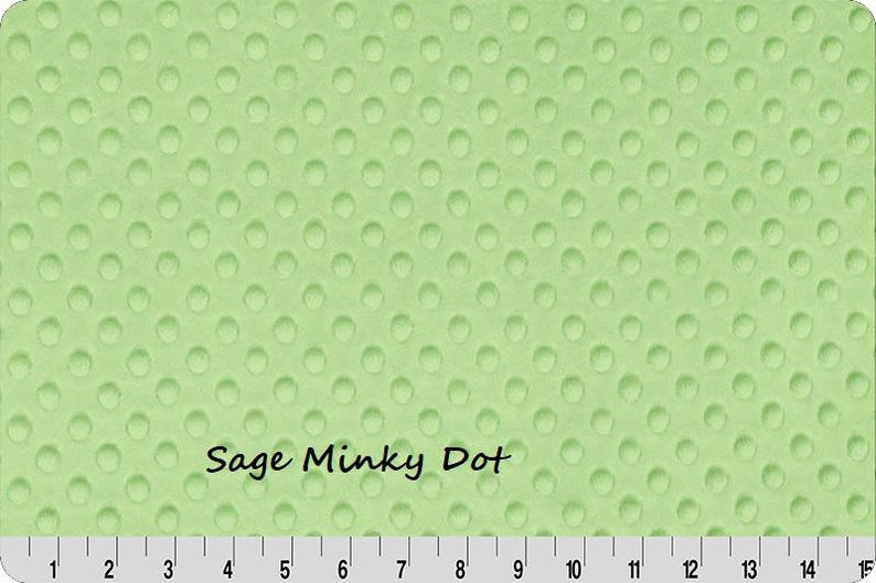 May include: Sage green Minky Dot fabric with a textured, dotted pattern. The fabric has a ruler along the bottom edge, with the text "Sage Minky Dot" in a handwritten font.