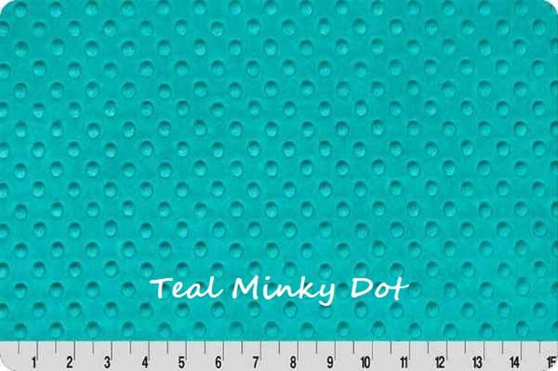 May include: Teal Minky Dot fabric with a raised dot pattern. The fabric is a vibrant teal color and features a repeating pattern of small, evenly spaced dots. A ruler is at the bottom, with measurements in inches.