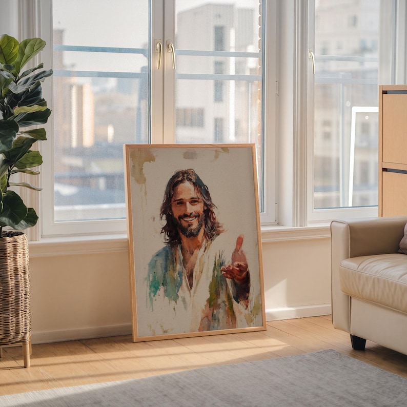 May include: A framed watercolor print of a man with long brown hair and a beard, wearing a white robe with blue and green accents. The man is smiling and extending his hand. The artwork is displayed in a well-lit room.
