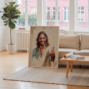 May include: A framed portrait of a man with long brown hair and a beard, wearing a white and blue robe. The painting has a watercolor style and is leaning against a wall in a well-lit room.