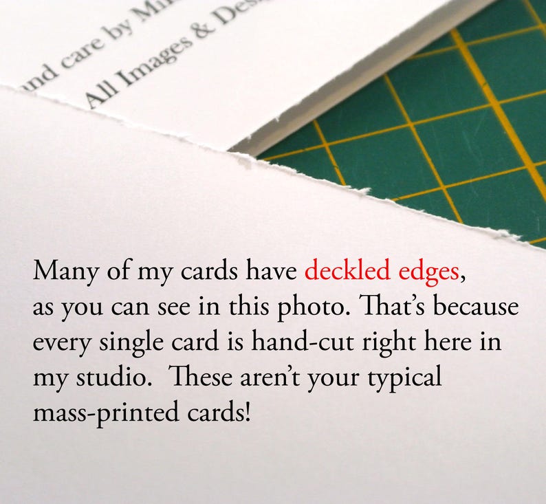 Op de afbeelding: Een witte kaart met een ruwe, onregelmatige geschepte rand. De kaart bevat zwarte gedrukte tekst die luidt: Many of my cards have deckled edges, as you can see in this photo. That&rsquo;s because every single card is hand-cut right here in my studio.
