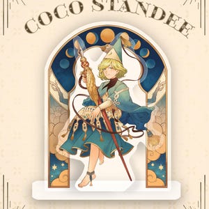 Könnte beinhalten: Eine Coco Standee-Hexenfigur in Teal und Gold, die einen Stab hält. Das Bild zeigt den Text "Witch Hat Atelier" und "Coco Standee" oben und "Preorders Open!" unten. Der Hintergrund ist hellbeige.