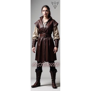 May include: A brown leather jacket with a brown belt and a beige shirt underneath. The jacket has a high collar and a short sleeve design. The person is wearing brown boots.