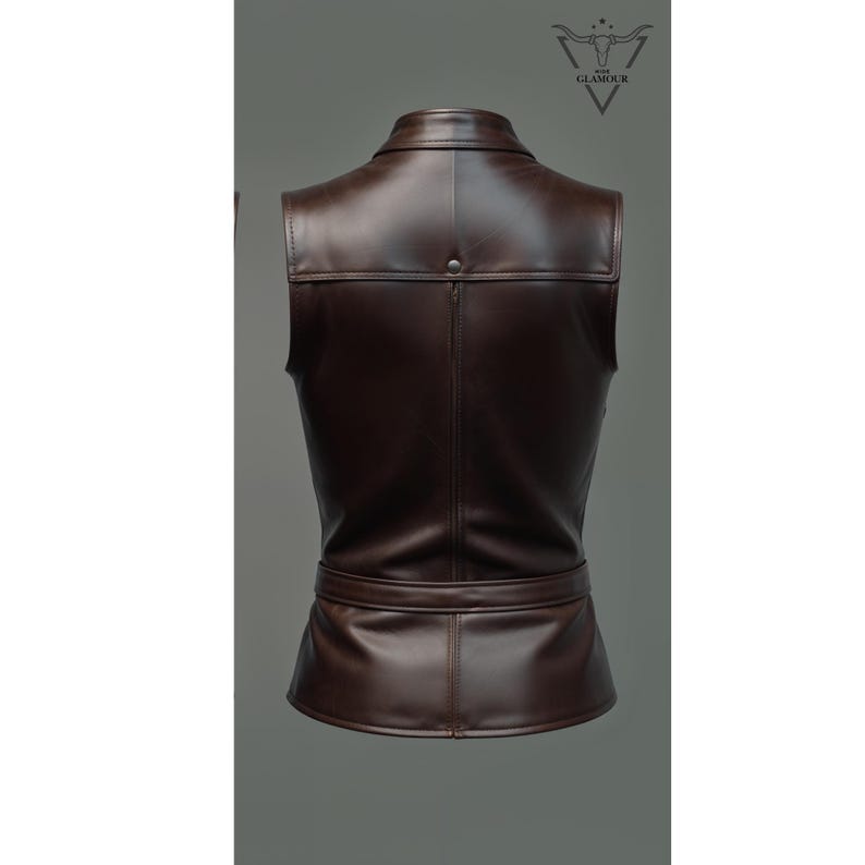 May include: A brown leather vest with a collar, a belt, and a button closure. The vest is sleeveless and has a fitted silhouette.