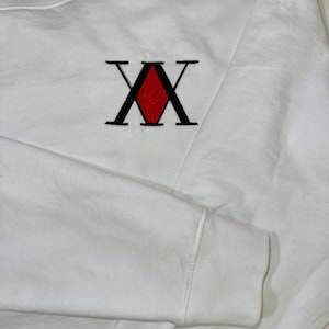 May include: White long-sleeve sweatshirt with a black and red embroidered 'X' logo.