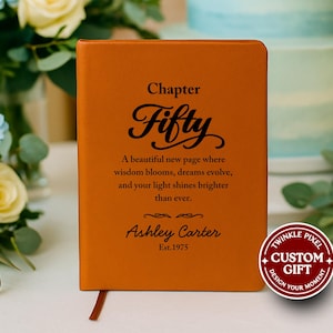 May include: Orange leather-bound journal with the text "Chapter Fifty" and a personalized message. The journal includes the name "Ashley Carter" and the year "Est.1975". A custom gift design sticker is on the right.