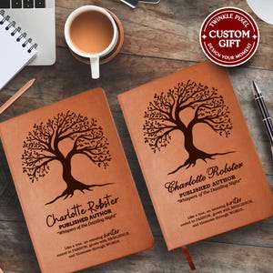 Peut inclure: Deux journaux en cuir marron avec un motif d'arbre et le nom "Charlotte Robster" sont présentés sur une surface en bois. Les journaux ont le texte "Whispers of the Dazzling Night" et une citation. Une tasse de café et un stylo sont également visibles.