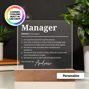 Può includere: Una targa in acrilico trasparente con base in legno che riporta la definizione di Manager e il nome Andrew. Il testo include 3 modalità e 7 colori di luce LED integrata. La targa elenca cinque definizioni numerate per il sostantivo Manager.
