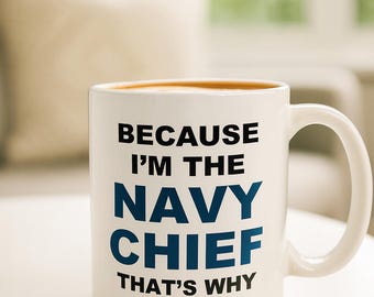 May include: White ceramic mug with the text "BECAUSE I'M THE NAVY CHIEF THAT'S WHY" in black and blue lettering. The mug is filled with a brown liquid and sits on a white surface.