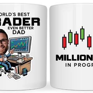 May include: White ceramic mug with a cartoon illustration of a trader at a desk, with the text "WORLD'S BEST TRADER EVEN BETTER DAD." The other side says "MILLIONAIRE IN PROGRESS" with stock market graphics.