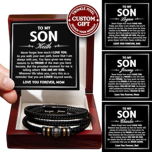 Peut inclure: Un bracelet en cuir noir avec des détails argentés et dorés est présenté dans un coffret en bois. La boîte contient une carte avec le texte "TO MY SON" et un message personnalisé. Le bracelet est un cadeau personnalisé.