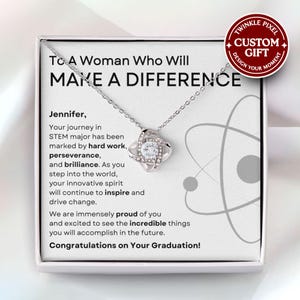 May include: A white gift box containing a silver necklace with a small, clear crystal pendant. The box features a message that reads "To A Woman Who Will Make A Difference" and "Congratulations on Your Graduation!"