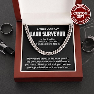 May include: A silver chain necklace in a gift box. The box features a card with the text "A Truly Great Land Surveyor" and a message of appreciation. The gift box is dark red with a white interior.