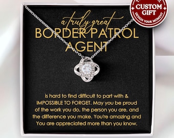 May include: A silver necklace with a sparkling pendant is displayed in a gift box. The box contains a card with the text "a truly great BORDER PATROL AGENT" and a message. A red circle reads "CUSTOM GIFT".