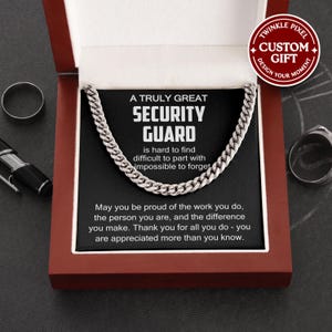Könnte beinhalten: Eine silberne Halskette in einer Geschenkbox. Die Box ist geöffnet und zeigt die Halskette und eine Karte mit dem Text "A TRULY GREAT SECURITY GUARD". Die Box ist rot mit weißem Innenraum.