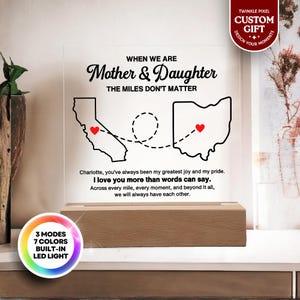 May include: A lighted acrylic sign with the text "When We Are Mother & Daughter The Miles Don't Matter." It features outlines of California and Ohio with hearts, and a wooden base. The sign has a built-in LED light with 3 modes and 7 colors.
