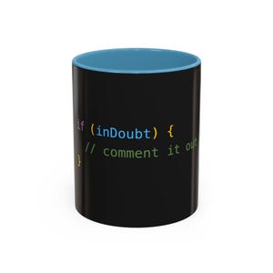 Może przedstawiać: Czarny kubek do kawy z niebieskim rantem. Kubek ma nadrukowany fragment kodu, który brzmi "if (inDoubt) { // comment it out }"