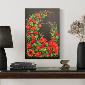 May include: A framed canvas art piece featuring a vibrant, stylized bird and floral design. The artwork showcases a red bird with detailed feathering, surrounded by a wreath of red flowers, green leaves, and berries against a black background.