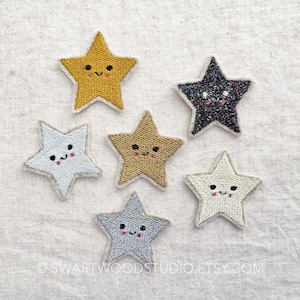 May include: Five embroidered iron-on patches in the shape of stars with different colors and patterns. The stars have smiling faces with pink cheeks.