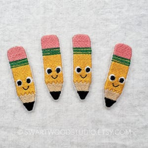 May include: Four embroidered yellow pencil patches with pink erasers and green bands. Each pencil has a smiling face with black eyes.