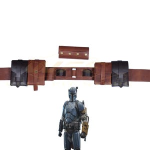 Könnte beinhalten: Ein brauner Ledergürtel mit mehreren Taschen und einem schwarzen Patch. Der Gürtel hat eine Metallschnalle und ist mit Nieten verziert. Der Gürtel wird von einer Figur in einem blau-grauen Anzug mit Helm getragen.