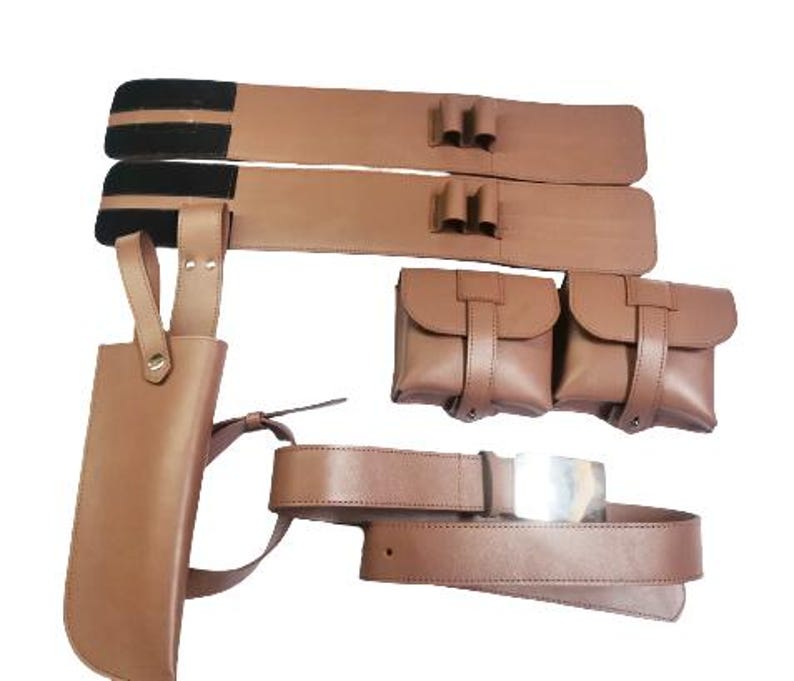 May include: A brown leather cosplay belt with two pouches and a holster. The belt has a silver buckle and is decorated with black straps.