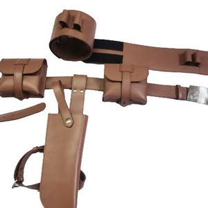 May include: Brown leather belt with multiple pouches and a holster. The belt has a silver buckle and a black elastic strap.