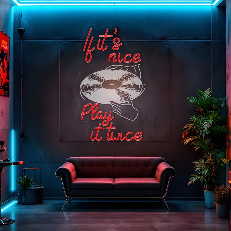May include: A black sofa with gold legs sits beneath a neon sign that reads "If it's nice, play it twice." The sign features a vinyl record design. The room has a dark aesthetic with blue and red neon lighting.