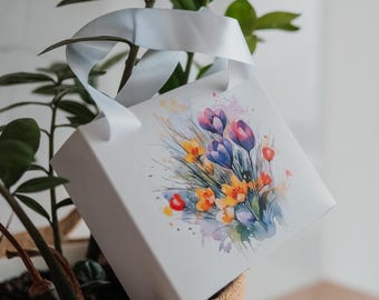 Caja de regalo con estampado floral y asas de cinta de satén.