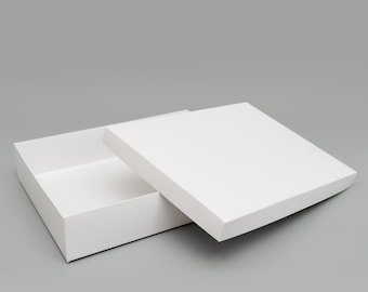 May include: A white cardboard box with a lid. The lid is open and the box is empty.