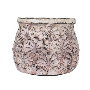 Puede incluir: Una maceta redonda de color blanquecino con un acabado envejecido. El exterior presenta un patrón repetido de hojas estilizadas. El borde es de un tono más oscuro, y el efecto general es rústico y decorativo.