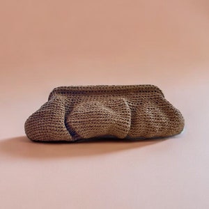 May include: A brown crocheted clutch bag with a gathered design.