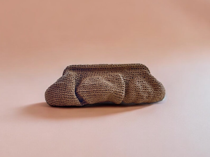 May include: A brown crocheted clutch bag with a gathered design.