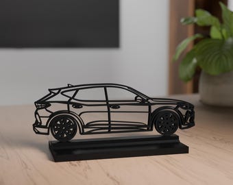 May include: A black, stylized car sculpture. The car is depicted in a linear, outline style, with visible wheels and windows. It sits on a rectangular base, also black. The sculpture is a decorative item.