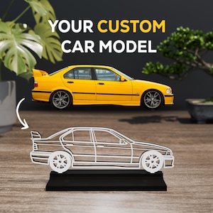 May include: A yellow saloon car model is displayed above a white wireframe outline of the same vehicle. The white outline is mounted on a black rectangular base. The text YOUR CUSTOM CAR MODEL is printed in white and yellow above the car images.