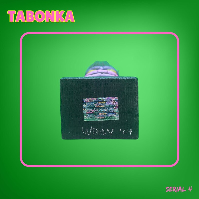 May include: A wooden figurine with a colorful, layered design. The figurine is on a black base with a holographic sticker and the text "Infinity '24".