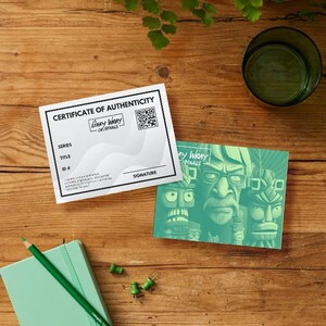 May include: A certificate of authenticity for a Gary Wray Originals print. The certificate is white with black text and a black and white QR code. The certificate is next to a green print featuring a cartoon character with a large nose and glasses.