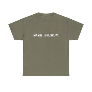 May include: A green t-shirt with the text "MAYBE TOMORROW." printed in white on the front.