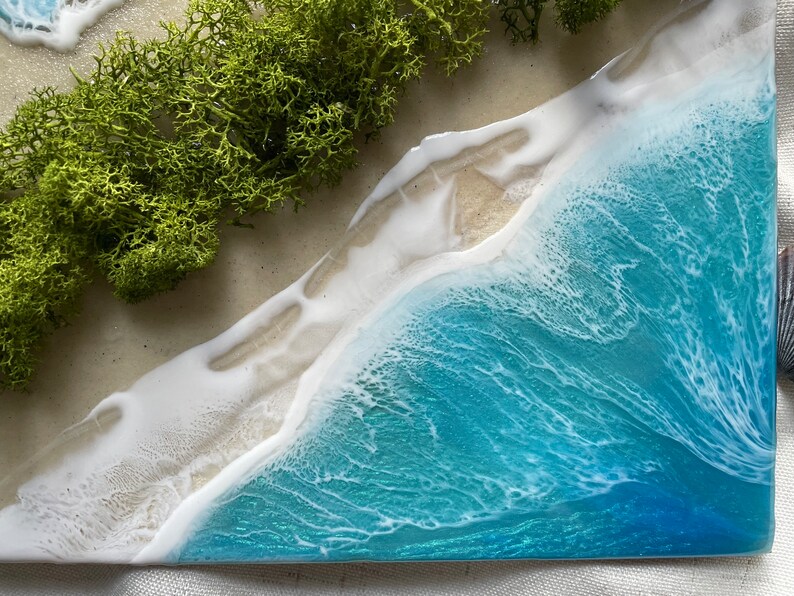 Pu&ograve; includere: Opera d'arte in resina raffigurante una scena di spiaggia con onde turchesi, schiuma bianca e una riva sabbiosa. &Egrave; incluso del muschio verde. Il pezzo &egrave; un oggetto decorativo unico.