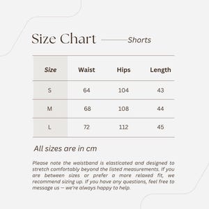 May include: Size chart for shorts, with measurements in centimeters. Sizes S, M, and L are listed, with waist, hips, and length measurements provided. The text states the waistband is elasticated and designed to stretch.