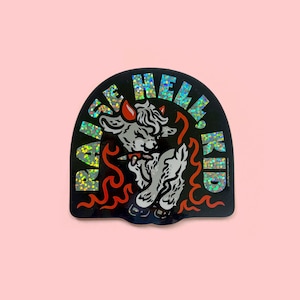 May include: A black and white sticker with a glittery rainbow effect. It features a cartoon devil goat with horns and a tail, surrounded by flames. The text "RAISE HELL KID" is written in a circular arc around the goat.
