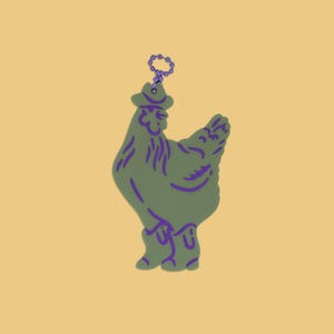 May include: A green chicken-shaped keychain with purple accents, wearing a cowboy hat and boots. The keychain has a purple ring for attachment. The background is a solid yellow color.