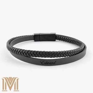 Peut inclure: Bracelet en cuir noir avec un design tressé et un fermoir en métal noir. Le bracelet est gravé du nom "Edward".