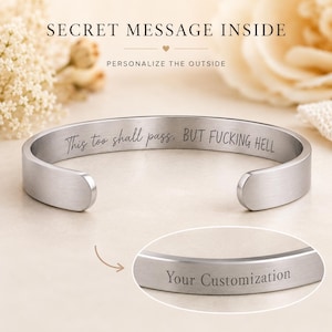 May include: A silver-toned metal cuff bracelet with an open back. The interior is engraved with the text 'This too shall pass. BUT FUCKING HELL'. A circular inset shows the exterior of the bracelet with the text 'Your Customisation'.