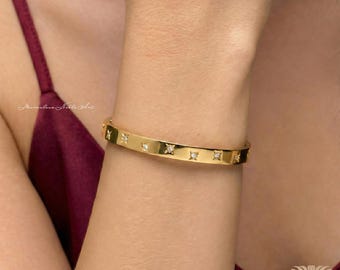 Pulsera rígida chapada en oro de 18 quilates grabada con estrellas de cristal.